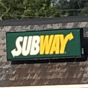 a subway sign on the roof of a building