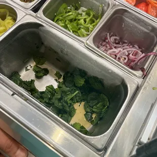a person holding a tray of vegetables