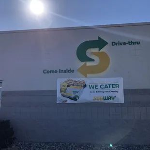 a drive thru sign on the side of a building