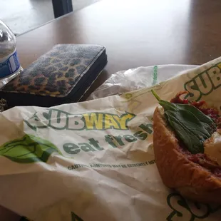 a sandwich and a water bottle on a table