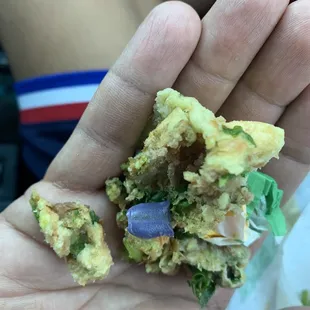 a person's hand holding a half eaten food item