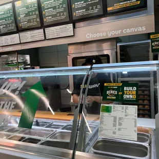 a man working behind the counter at a subway