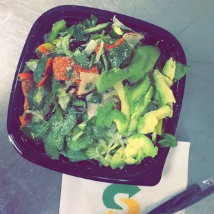 a salad in a black bowl with a fork