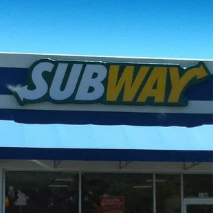 a red car parked in front of a subway
