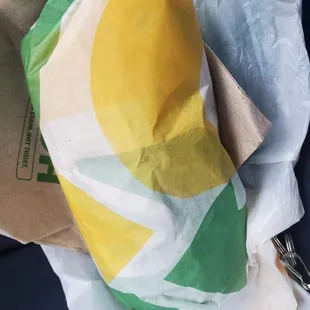 a sandwich wrapped in a paper bag