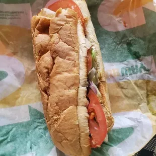 a sub sandwich with tomatoes and lettuce
