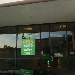 a green sign in the window of a subway