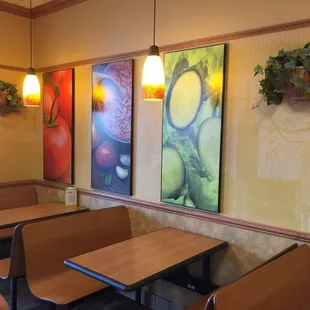 Art on this wall is in a large, frameless, turn-of-the-century style with bold colors.