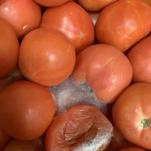 a pile of rotten tomatoes and oranges