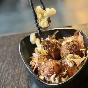 a bowl of food with chopsticks