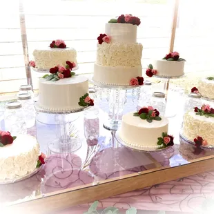 A multi-flavor 10-tier cascading wedding cake with Swiss meringue buttercream, sage, and fresh roses.
