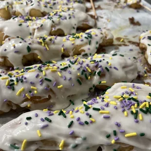 a tray of donuts with icing and sprinkles
