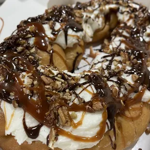 a donut covered in whipped cream and nuts