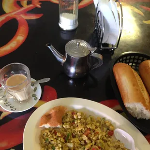 Fried Eggs with bread and a pot of tea with milk.