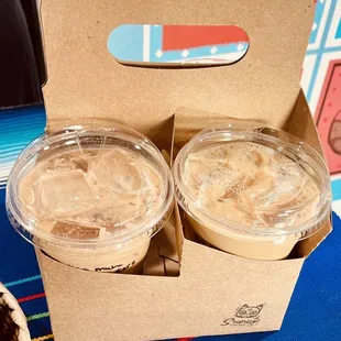 three cups of iced coffee in a cardboard box