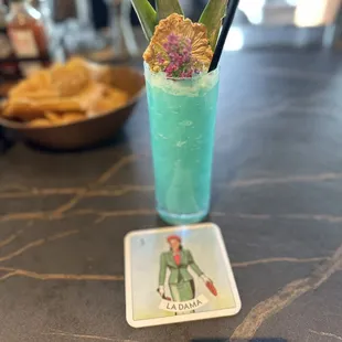 a blue drink with a flower in it