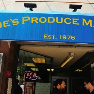 two men standing in front of the store