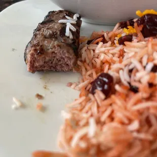 a plate of rice, meat and vegetables