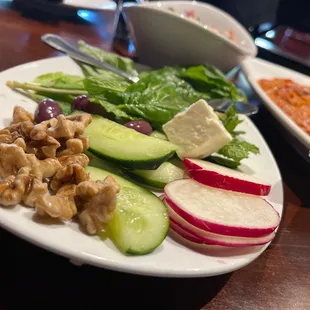 Complimentary salted cheese cube, nuts, radish and cucumber slices and mint leaves for the table