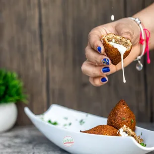 a person sprinkling salt onto a plate of food