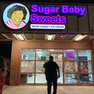 a man and a little girl walking in front of the store