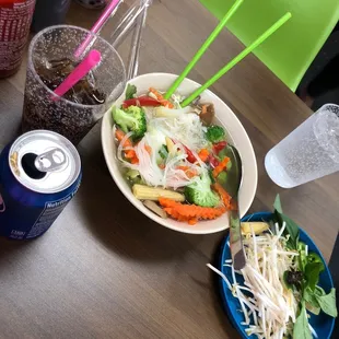 a bowl of salad and a can of soda