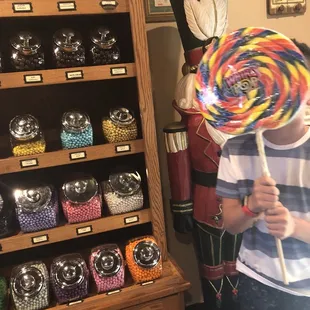 a young boy holding a lollipop
