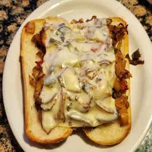 Hot chicken sandwich. Chicken, onion, bellpepper, mushrooms with melted cheese on a toasted roll.