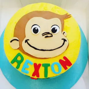 a monkey face on a yellow and blue cake