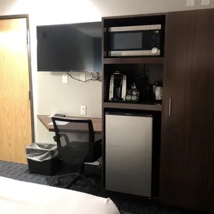 Desk, armoir, mini fridge, Keurig coffee maker, and microwave
