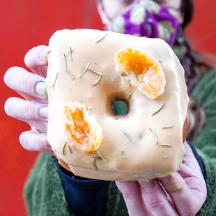 a woman holding a glazed donut