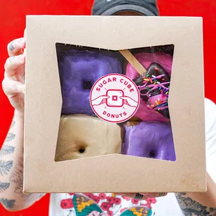 a man holding a box of doughnuts