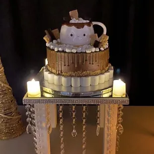 Ceramic mug filled with marshmallows atop a s'mores cake