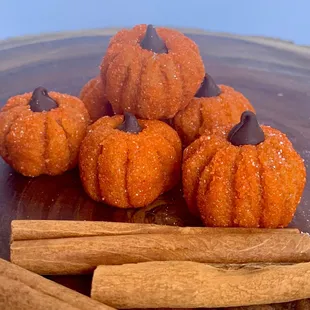 a pile of sugared pumpkins and cinnamon sticks