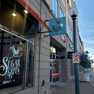 a street corner with a sign for sugar grits