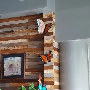 a living room with a fireplace and a picture of a butterfly on the wall