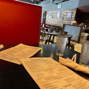 a menu and a glass of water on a table