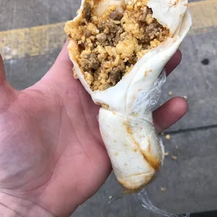 a hand holding a burrito