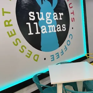 a table and chairs in front of a sign that says sugar llamas