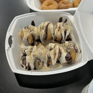 a couple of doughnuts in a styrofoam container