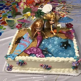 a decorated cake with barbies on it