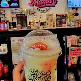 a hand holding a cup of ice cream