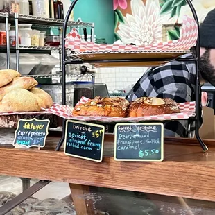 a man behind a counter with pastries