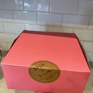 a hand holding a pink box