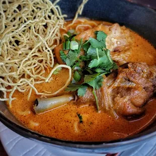 Kao Soi Kai - Northern Thai dish made with a mix of deep-fried crispy egg noodles and boiled egg noodles in curry-like sauce with chicken