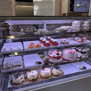 Display case with whole cakes, cheesecakes, and pie slices