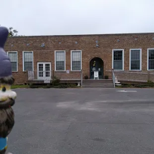 the front of a brick building with a gnome statue in front of it