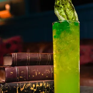 a green cocktail with a leaf on top