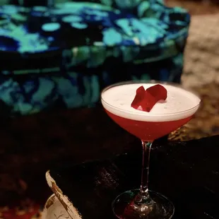 The Rose Colored Glasses: Vodka, cranberry, lime citrus, rose hibiscus, blanc vermouth, dry curaçao rose petal garnish and rose water.