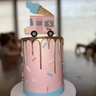 a pink cake with gold drips